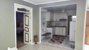 a kitchen with a door open to a kitchen with white cabinets at Apartments Firuze in Gabala