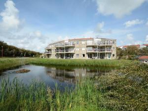 ein Gebäude neben einem Fluss mit einem Gebäude in der Unterkunft Apartment in Julianadorp near the Beach in Julianadorp