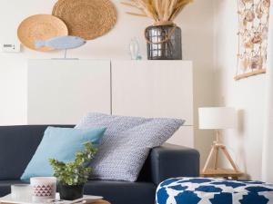 ein Wohnzimmer mit einem blauen Sofa und einem Tisch in der Unterkunft Apartment in Julianadorp near the Beach in Julianadorp