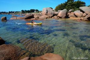a person in a yellow kayak in the water at Gîte De L'alliance in Lannion +12 photos
