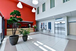 an empty lobby of a hospital with two potted plants at Zenitude Hôtel-Résidences Le Havre Les Docks in Le Havre