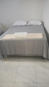 a bed with two pillows on it in a room at A M Hotel in São Luís