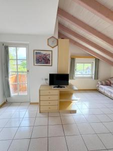 a living room with a tv on a wooden dresser at Casa El Tobià in Pozza di Fassa