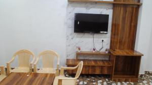 Una sala de estar con dos sillas y un televisor de pantalla plana. en Manimahesh Home Stay, en Banikhet