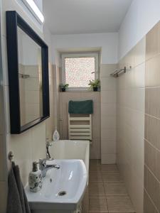 Un baño con lavabo, espejo y ventana. en Sunset Bucharest, en Bucarest 36 fotos más