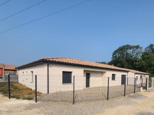 a white building with a fence in front of it at Maison Noé Climatisation individuelle par pièce proche du centre-ville in Ruoms