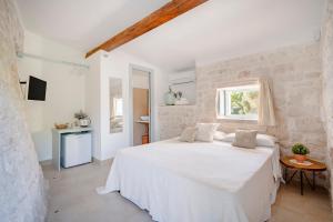 Un dormitorio blanco con una cama blanca y una ventana. en Trulli in Contrada - Monopoli, en Monopoli