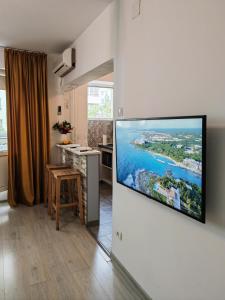 Una sala de estar con un televisor de pantalla plana en una pared. en Sunset Bucharest, en Bucarest