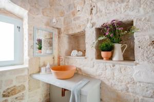 Un baño con paredes de piedra y un lavabo sobre una encimera. en Trulli in Contrada - Monopoli, en Monopoli