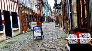 a cobblestone alley with a sign on a street at Chambre dans le centre historique in Pont-Audemer