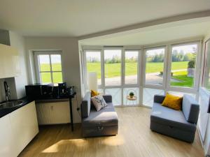 a living room with a couch and a kitchen with windows at Harztraum-6 in Braunlage