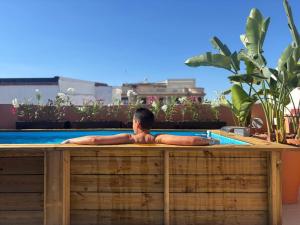 un hombre yace en una piscina en The Loft House Sevilla, en Sevilla