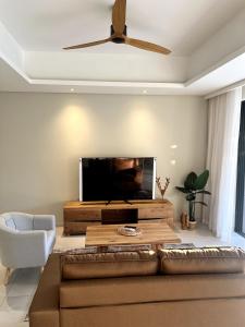 a living room with a couch and a flat screen tv at Mont Choisy Golf & Estate Suite in Grand Baie