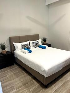 a bedroom with a large white bed with blue pillows at Mont Choisy Golf & Estate Suite in Grand Baie +31 photos