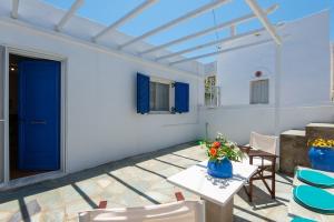 a patio with a table and chairs and a blue door at VORINI'S HOUSE, Exampela,Sifnos in Katavatí