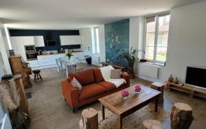 un salon avec un canapé et une table dans l'établissement Domaine Les Chauveaux, 3 gites, 26 personnes, 1 salle, à Antran