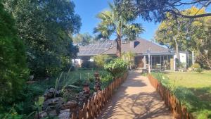una casa con una recinzione di fronte a un cortile di Carrington Cottage a Kimberley