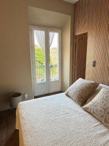 Un dormitorio con una cama y una ventana grande. en STUDIO SPACIEUX TOUT CONFORT CITE IMPERIALE, en Ajaccio