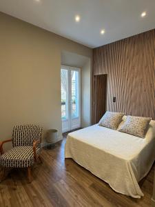 Un dormitorio con una cama y una silla y una ventana. en STUDIO SPACIEUX TOUT CONFORT CITE IMPERIALE, en Ajaccio
