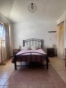 - une chambre avec un lit et une couverture violette dans l'établissement Casa79sancris, à San Cristóbal de Las Casas