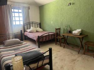 une chambre avec deux lits et une table et une fenêtre dans l'établissement Casa79sancris, à San Cristóbal de Las Casas 2 autres photos