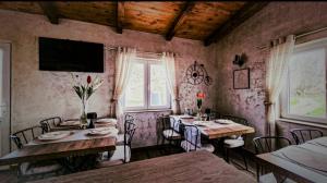a dining room with two tables and chairs and a window at Castio del Monte Winery & Resort in Petrovac na Moru