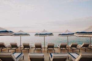 a group of chairs and umbrellas on a beach at Hotel de Mar Gran Meliá - Adults Only - The Leading Hotels of the World in Illetas +37 photos