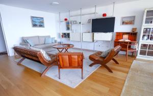 a living room with a couch and a tv at Atlantis Ocean Front in Vila Nova de Gaia