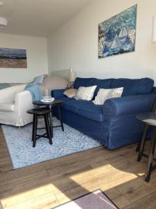 a living room with a blue couch and tables at Baltic Sea View in Fehmarn