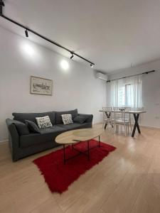 a living room with a couch and a table at Kadare City-Center Apartment with Balcony in Tirana