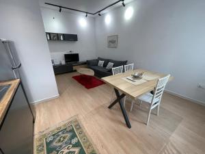 a living room with a table and a couch at Kadare City-Center Apartment with Balcony in Tirana