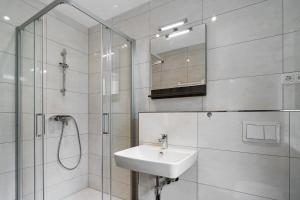 a white bathroom with a sink and a shower at Förde Hotel Kiel in Kiel