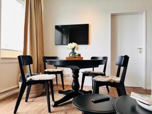 a dining room with a black table and chairs at Baltic Sea View in Fehmarn +19 photos