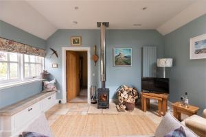 a living room with a wood stove and a tv at The Heritage Cottage in Swinton