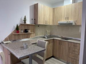 a kitchen with wooden cabinets and a sink and a table at Piazza Downtown Cozy Studio in Tirana