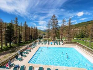 a swimming pool with chairs and people in it at Vars Les Claux - Résidence l'Albane in Vars