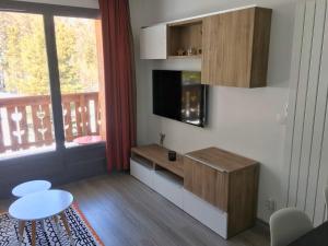 a living room with a television and a table at Vars Les Claux - Résidence l'Albane in Vars