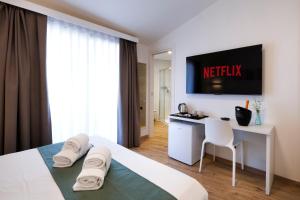 a hotel room with a bed and a desk and a television at Maradiva in Villasimius