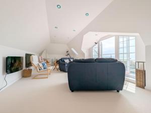 Una sala de estar con un sofá azul y un televisor. en The Dunes - Swimming Pool, en Bognor Regis