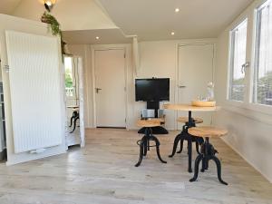 een woonkamer met een tafel en een tv bij Studio het Strandhuis KA05 in Vlissingen