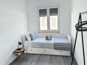 a small bedroom with a bed and a window at Waves and Trails in Porto Covo +9 photos