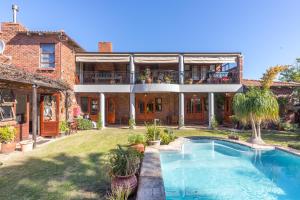 a large house with a swimming pool in the yard at Tambula Guest House in Cape Town