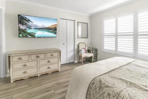 Un dormitorio con una cama y un televisor en la pared. en Isla del Sol Condos for Rent, en San Petersburgo 29 fotos más