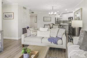 Una sala de estar con un sofá blanco y una cocina. en Isla del Sol Condos for Rent, en San Petersburgo