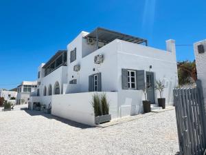 a white house with a fence in front of it at aeolian blu 2 in Parikia +35 photos
