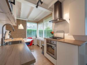 a kitchen with a sink and a stove top oven at Holiday Home near Sint Maartenszee Beach in Sint Maartensvlotbrug