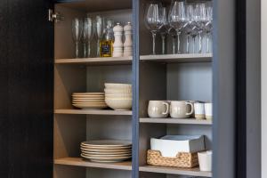 a cupboard filled with dishes and wine glasses at De Lindekamer in Loenen aan de Vecht