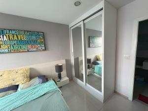 a bedroom with a bed and a large mirror at Acqua Condo By Dw in Ban Nong Chaeng