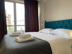 Un dormitorio con una cama grande con toallas. en Boutique Central Studio Apartments, en Tirana