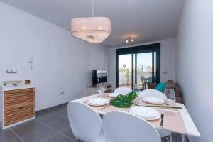 une salle à manger avec une table et des chaises et une cuisine dans l'établissement Apartamento costero en una comunidad de lujo, à Arenales del Sol